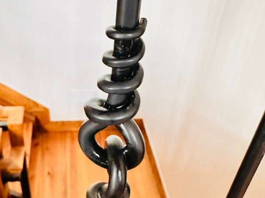 Forged iron stair railing detail wiped down by hand