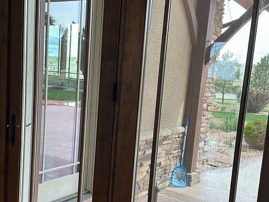 French doors with the glass cleaned, looking out to a covered porch