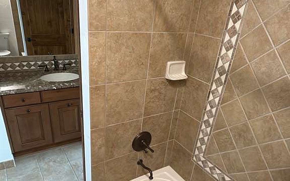 Bathtub and tiled surround with mosaic border after cleaning
