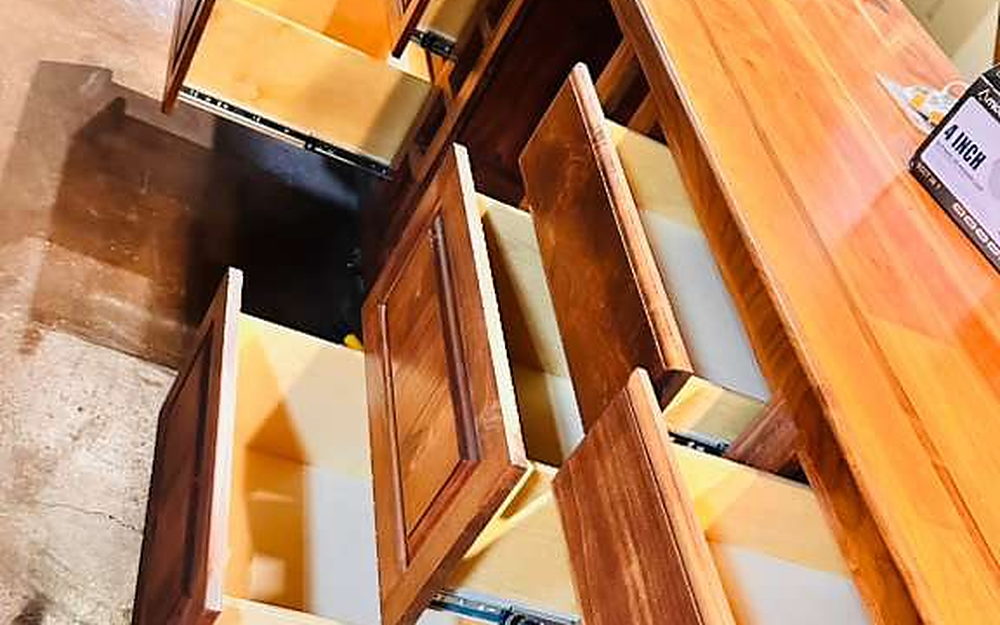 Cabinet doors and drawers opened to clean every interior on a move-out job