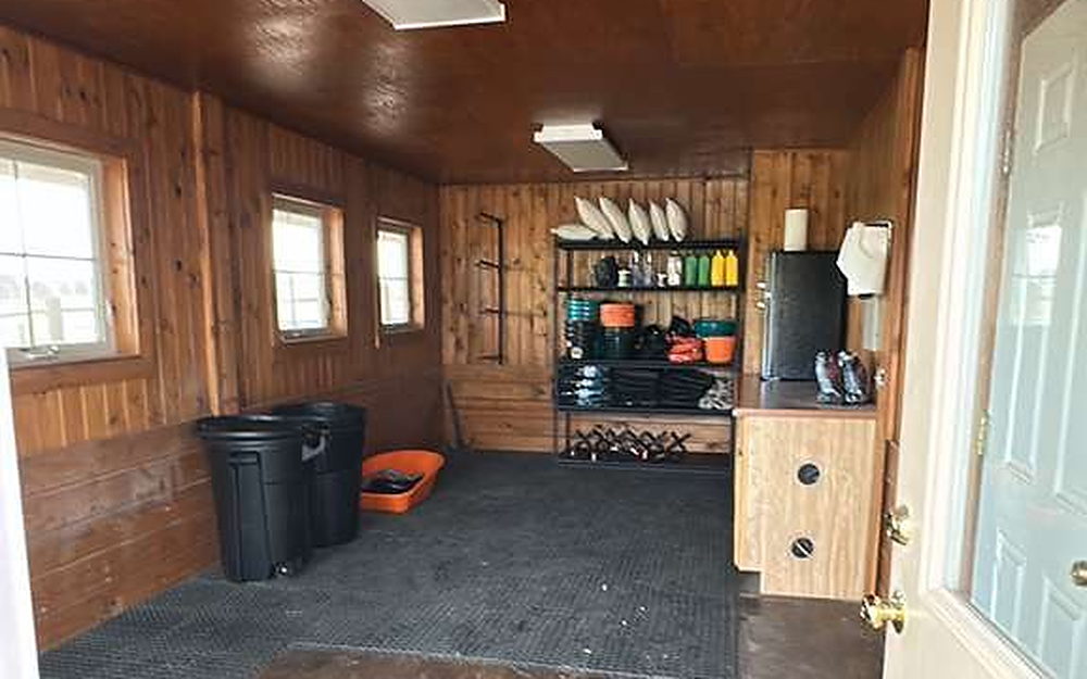Workshop entry with wood-lined walls, storage shelving and a swept floor