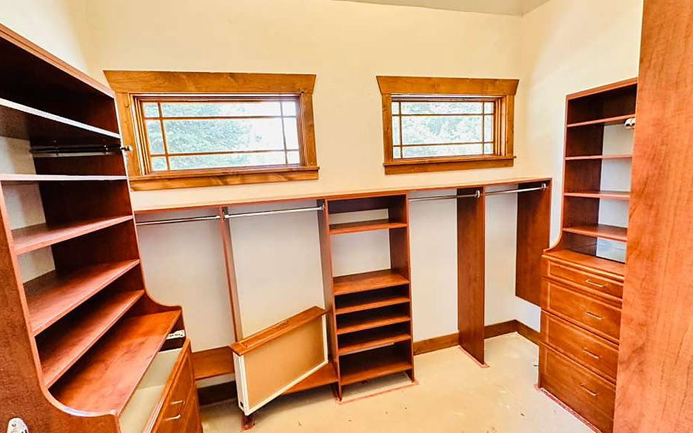 Walk-in closet with built-in wood shelving cleaned shelf by shelf