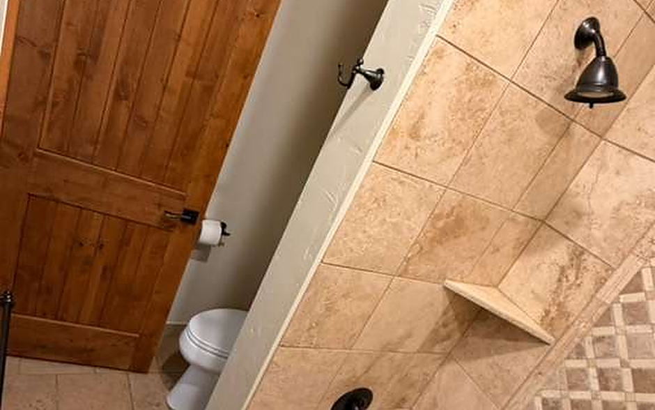 Bathroom with tiled tub surround, mosaic border and travertine floor cleaned