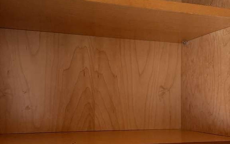 Open shelving above a quartz backsplash, wiped down