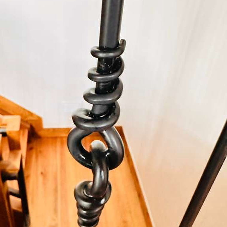 Forged iron stair railing detail wiped down by hand