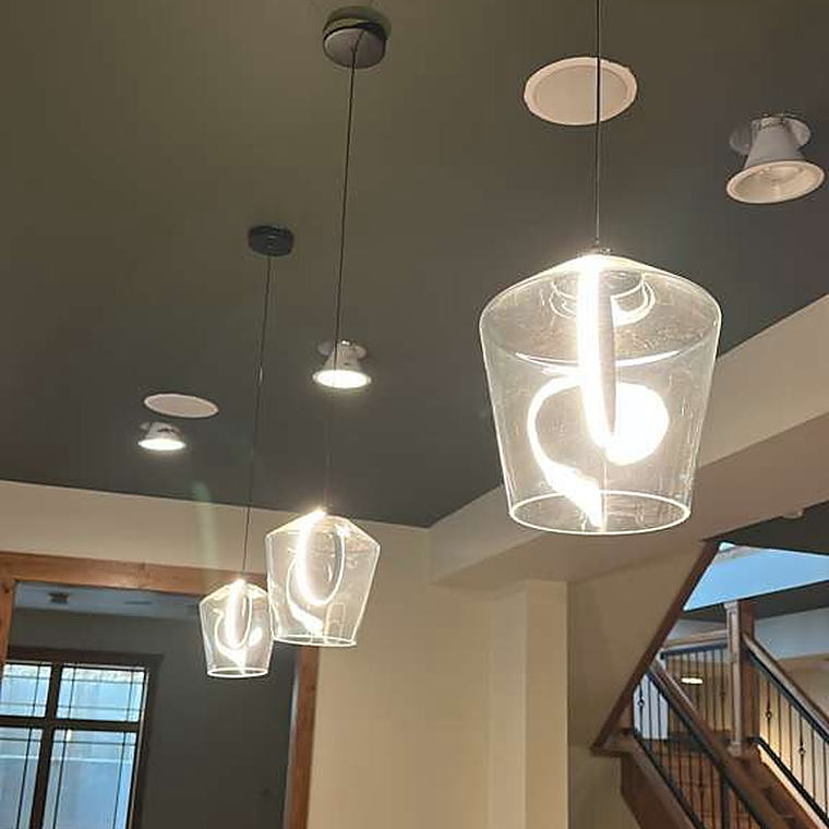Glass pendant lights cleaned above a wood counter