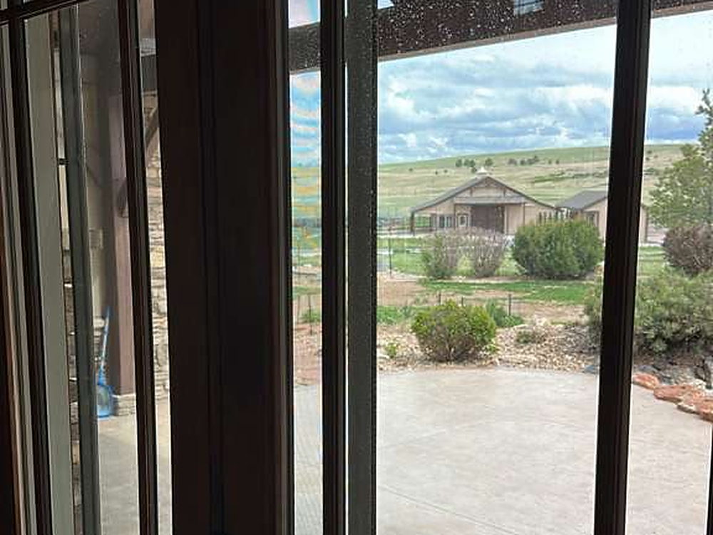 Glass patio doors cleaned, with open country visible beyond
