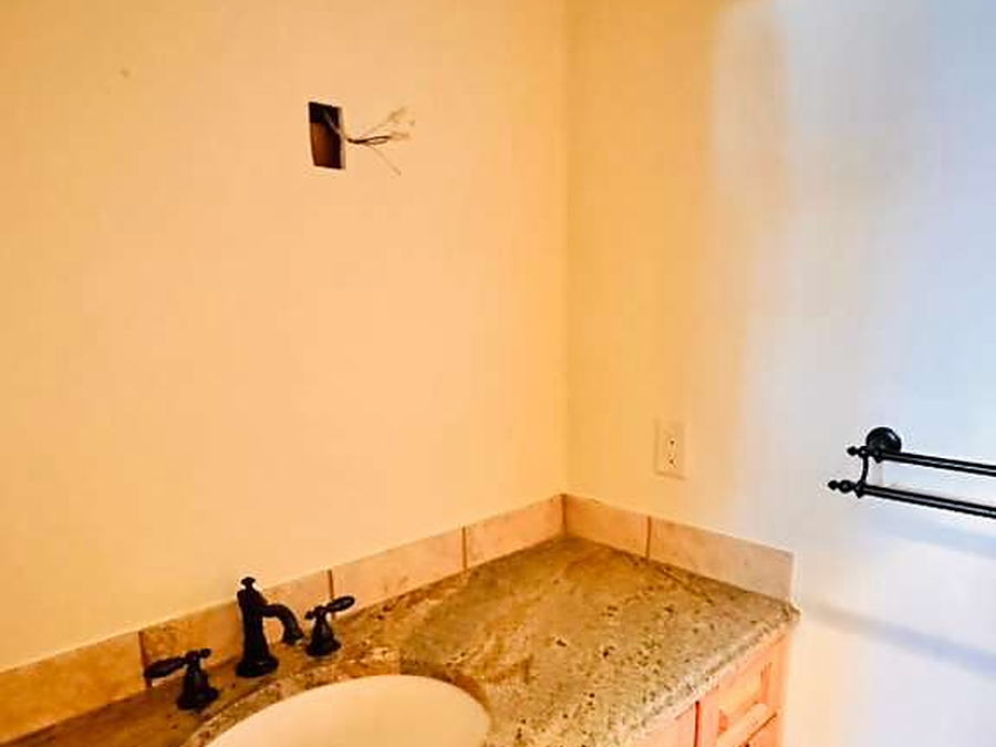 Bathroom with granite counter, oval sink and alder cabinets cleaned