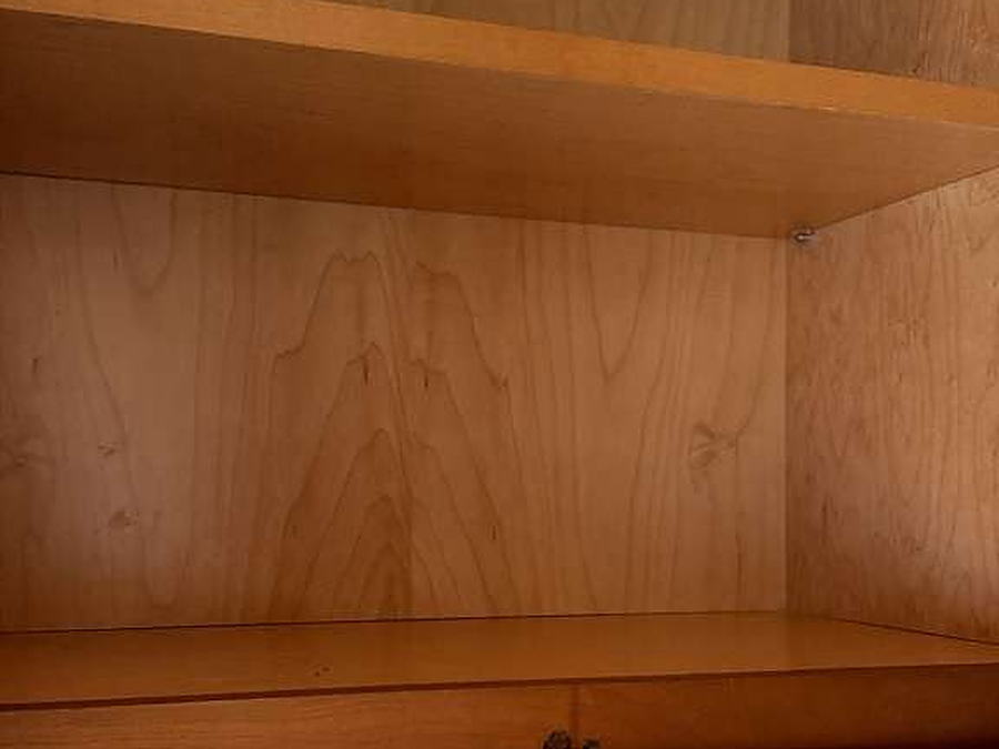 Open shelving above a quartz backsplash, wiped down