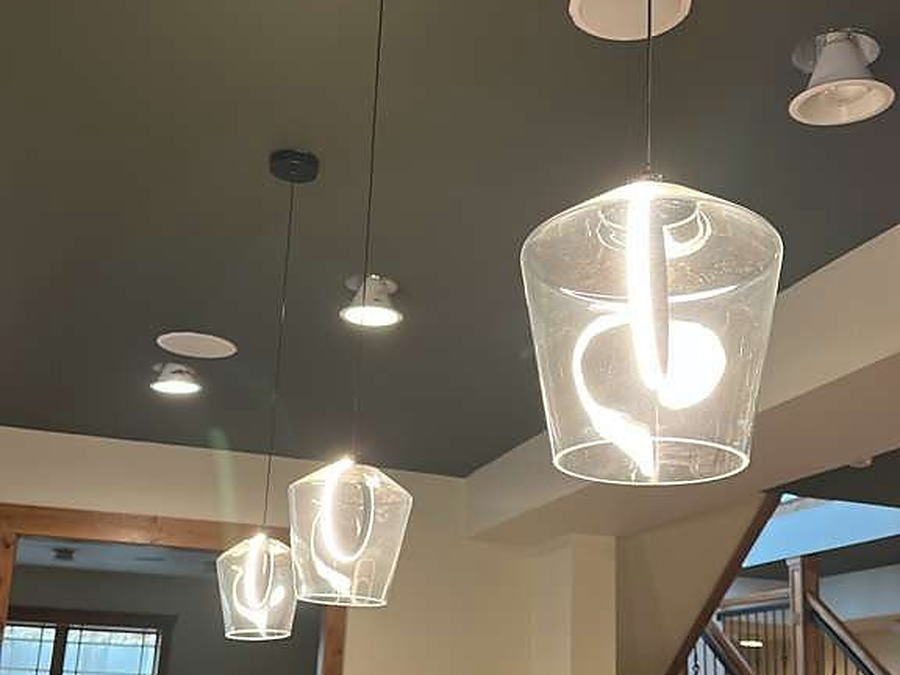 Glass pendant lights cleaned above a wood counter