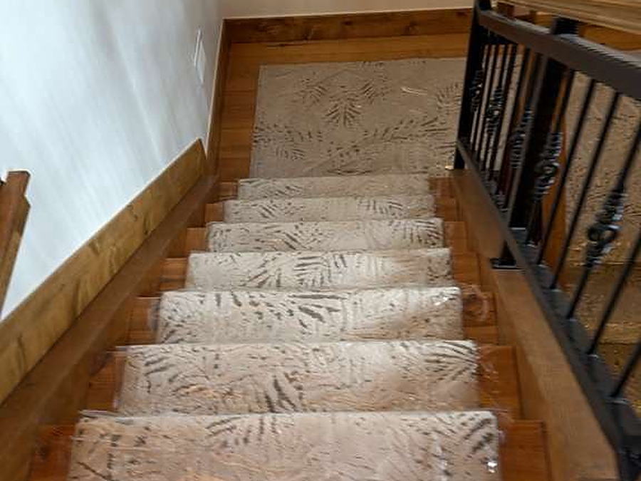 Staircase with protective covering laid over the carpet runner during a cleaning visit