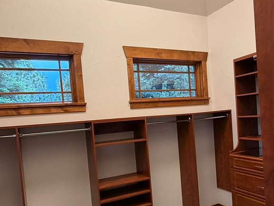 Walk-in closet with wood shelving and clean carpet